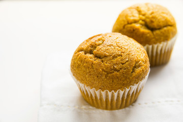 Homemade Whole Wheat Bran Carrot Muffin on White Cotton Kitchen Towel. Breakfast Morning Sunlight. Healthy Pastry Baking Concept. Minimalist Style Copy Space