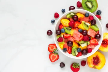 Foto op Canvas Bowl of healthy fresh fruit salad on white marble background. healthy food. top view © samael334