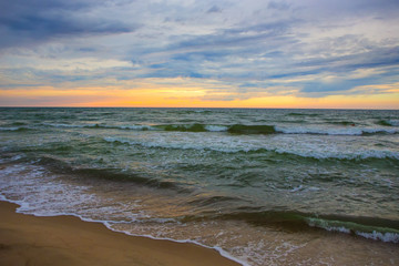sunset in the cloudy sky over the sea