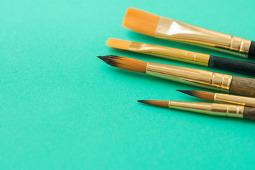 Bunch of Various Kinds of Paint Brushes on Light Green Background. Copy Space for Artwork Lettering Calligraphy Text Inspirational Quote. Creativity Arts Business Product Branding Promotion