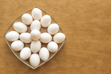 white eggs on wooden table, space for text
