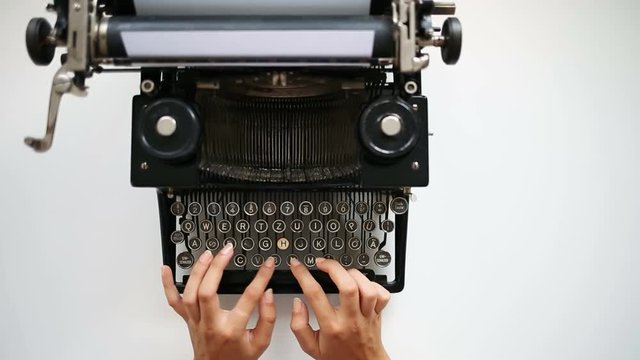 High angle view of writer typing on vintage typing machine. Writer typing with retro typewriter