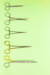 Medical equipments including surgical instruments on a green background. top view, copy spase