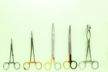 Medical equipments including surgical instruments on a green background. top view, copy spase