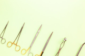 Obraz premium Medical equipments including surgical instruments on a green background. top view, copy spase
