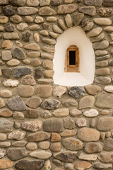 Old round stone wall with small window