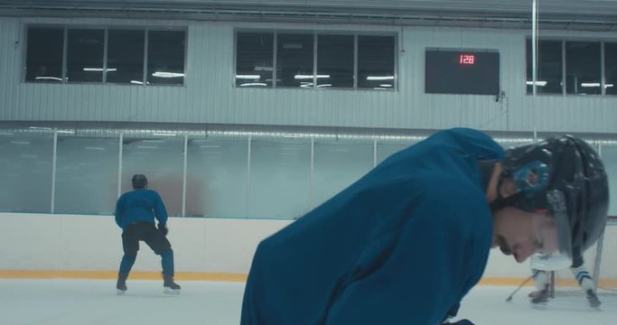 Caucasian male ice hockey player fails during skating practice at the training arena. 4K UHD 60 FPS SLOW MOTION