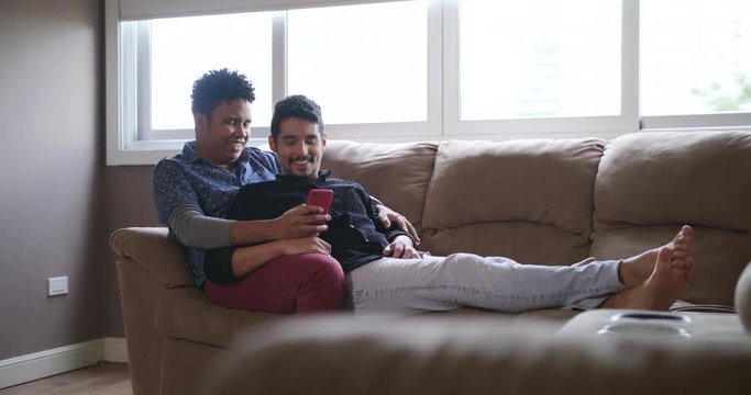 Happy Gay Couple Looking At Pictures On Mobile Phone