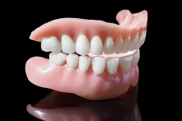 Medical denture smile jaws teeth close up isolated on black background