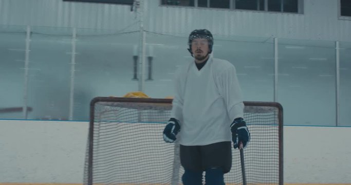 Caucasian male ice hockey player practicing skating drills at the training arena alone. 4K UHD
