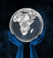 Burundi on translucent globe in hands