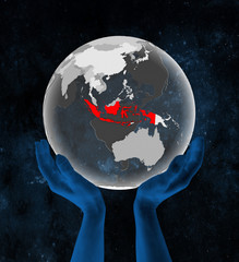 Indonesia on translucent globe in hands