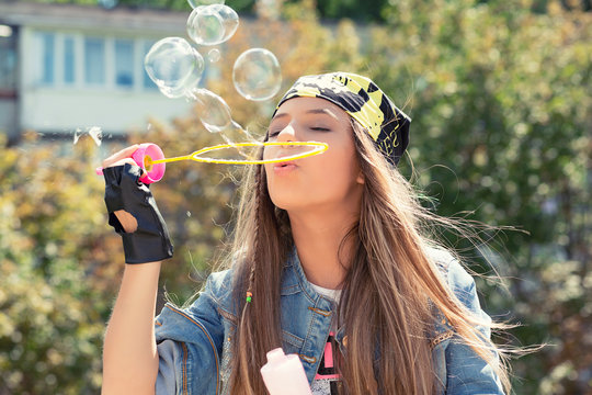 Playful woman blowing soap bubbles