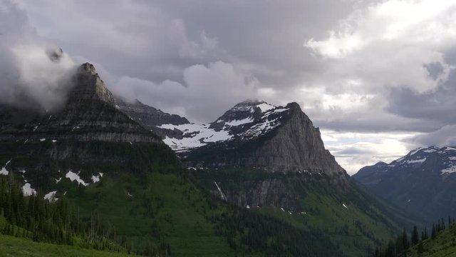 panning shot of storm clouds lifting from mt oberlin at glacier national park in montana, usa