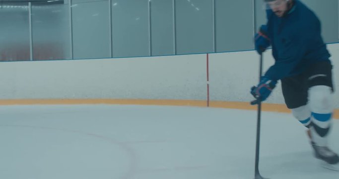 Caucasian male ice hockey player practicing shooting at the training arena alone. 4K UHD