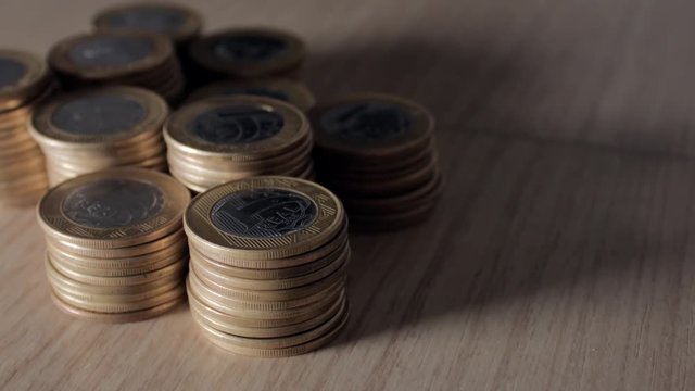 Stacks of Brazilian coins scattered across the table