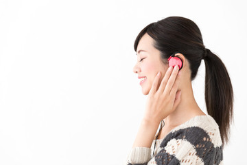 Fototapeta premium portrait of youg asian woman listening music on white background