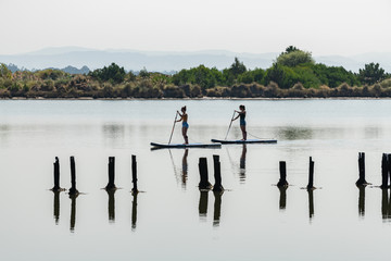Two women stand up paddleboarding