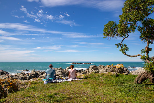 Two people enjoying a picnic and enjoying the view of the Kaikoura coastline  on a beautiful spring day