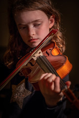 girl concentrating on playing violin