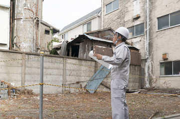 工事現場イメージ・建物解体現場　図面を持つビジネスマン