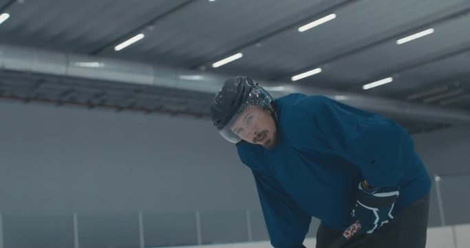 Caucasian male ice hockey player catching breath during practice at the training arena. 4K UHD