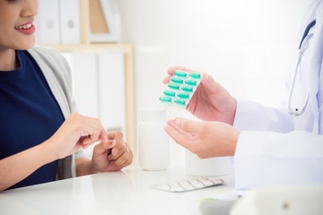 Doctor explain medication to female patient in clinic