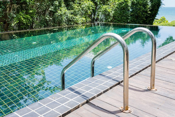 Grab bars ladder in the blue swimming pool