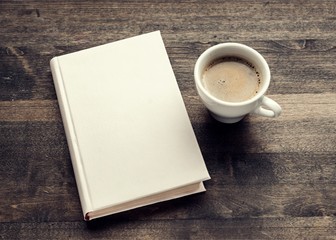 Cup of hot coffee with notebook on wooden table background, top