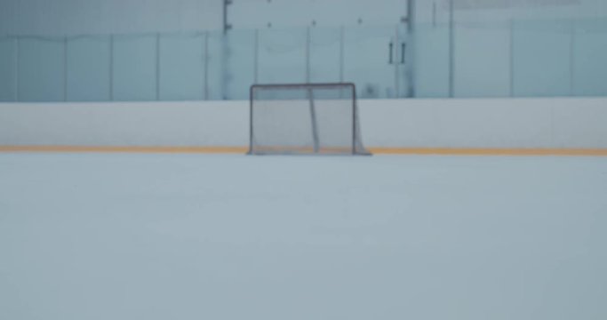CU ice hockey player shooting a puck at the training arena. 4K UHD