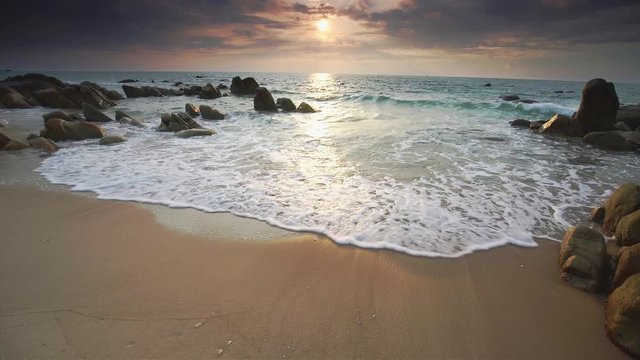 Dawn on beautiful beaches with white sand streaks waves like silk to create many beautiful shapes on the beach has many rocks,