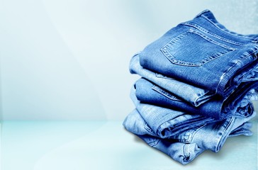 Pile of blue jeans over white background