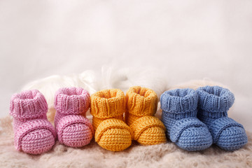 pregnancy concept, Three pairs of baby booties on a light background