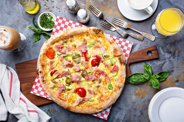 Breakfast pizza with scrambled egg, ham and tomatoes