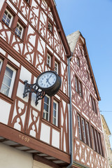 Fototapeta na wymiar City clock on the half-timbered facade of a house in the center of Trier
