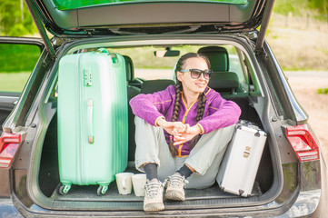 Woman traveler sitting in hatchback car