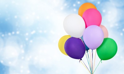 Bunch of colorful balloons on blurred blue background. Bokeh