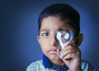 Save Energy- Creative Portrait of cute little indian asian caucasian boy child holding bulb in hand