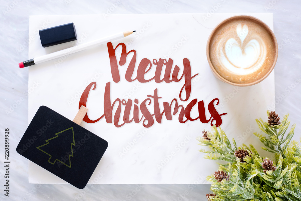 Poster top view of red merry christmas text on marble table with blackboard, pencil, eraser pine leaf and c