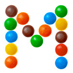 Letter M of sweet colored candies, alphabet isolated on white