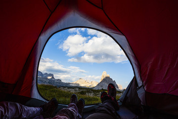Bivouac at Tre Cime di Lavaredo, family resting in tent, red illuminated tent on pass in Dolomites, Italy © Gorilla