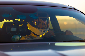 A Helmeted Driver At The Wheel Of His Race Car