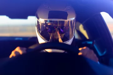Zelfklevend Fotobehang Een gehelmde bestuurder aan het stuur van zijn raceauto © SIX60SIX