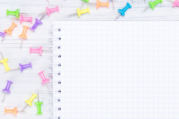 white checkered notebook and buttons for paper close-up on the table