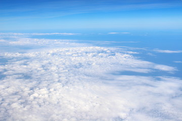 Wing of an airplane flying above the cloud looks from the window of the plane