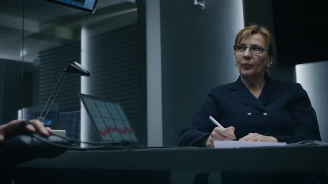 Female Special Agent Conducts Lie Detector / Polygraph Test on a Anonymous Suspect. Expert Examiner Questions Accused in Interrogation Room. Computer Records Measures Physiological indices.