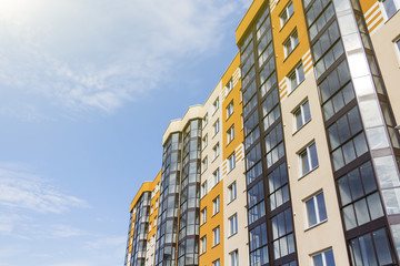 Modern apartment building in sunny day against blue sky.