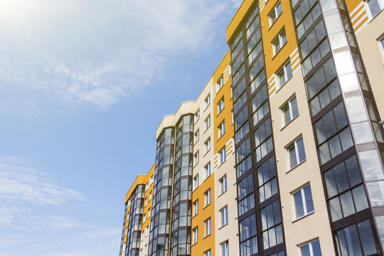 Modern apartment building in sunny day against blue sky.