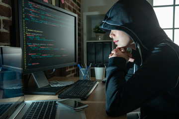 female hacker staring at the screen smiling. - obrazy, fototapety, plakaty
