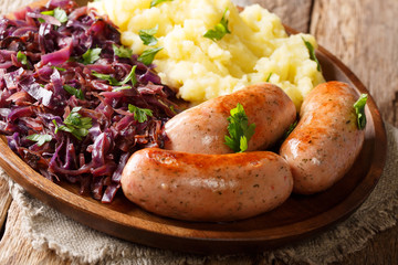 Home-style meal of mashed potatoes with fried red cabbage and sausages close-up on a plate. horizontal